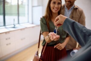 A couple joyfully holds keys to their new home.